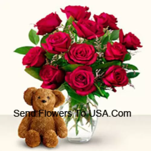 12 Rose Rosse con alcune felci in un vaso di vetro insieme a un adorabile orsacchiotto marrone alto 12 pollici