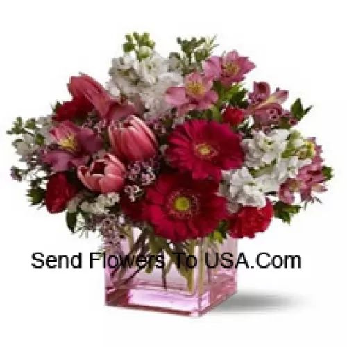 Rote Rosen, rote Tulpen und bunte Blumen mit saisonalen Füllstoffen, die wunderschön in einer Glasvase arrangiert sind