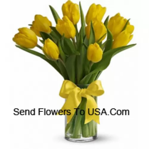 Tulipanes amarillos con rellenos y hojas estacionales en un jarrón de cristal - Tenga en cuenta que en caso de no disponibilidad de ciertas flores estacionales, las mismas serán sustituidas por otras flores de igual valor