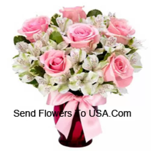 Schön angeordnete rosa Rosen und weiße Alstroemeria in einer Glasvase