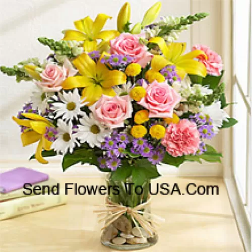 Rosa Rosen, rosa Nelken, weiße Gerbera und gelbe Lilien mit saisonalem Füllmaterial in einer Glasvase